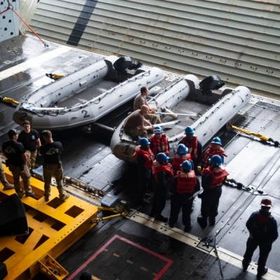 U.S. Navy personnel are seen in the well deck of USS John P. Murtha as they prepare equipment for the...