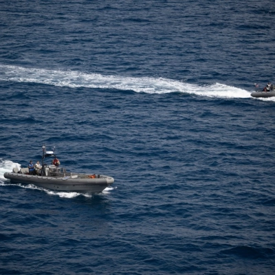 Small boats are seen alongside USS John P. Murtha as teams prepare to recover Artemis II crewmembers NASA astronauts Reid...